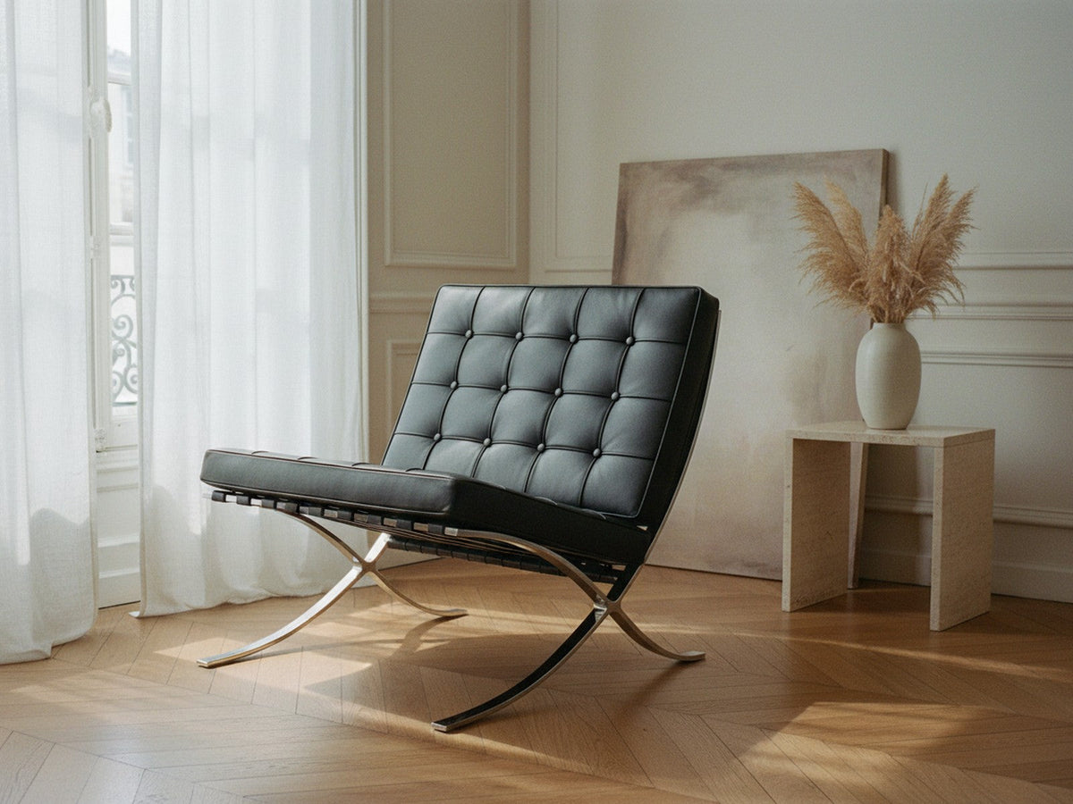 Fauteuil Capiton en cuir noir capitonné et acier poli, dans un salon parisien à parquet en point de Hongrie