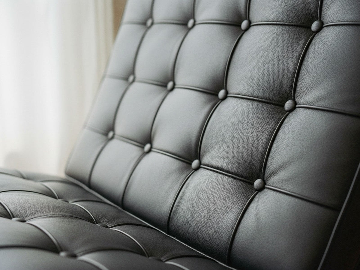 Détail du capitonnage du Fauteuil Capiton : carrés de cuir cousus un par un, passepoils et boutons recouverts